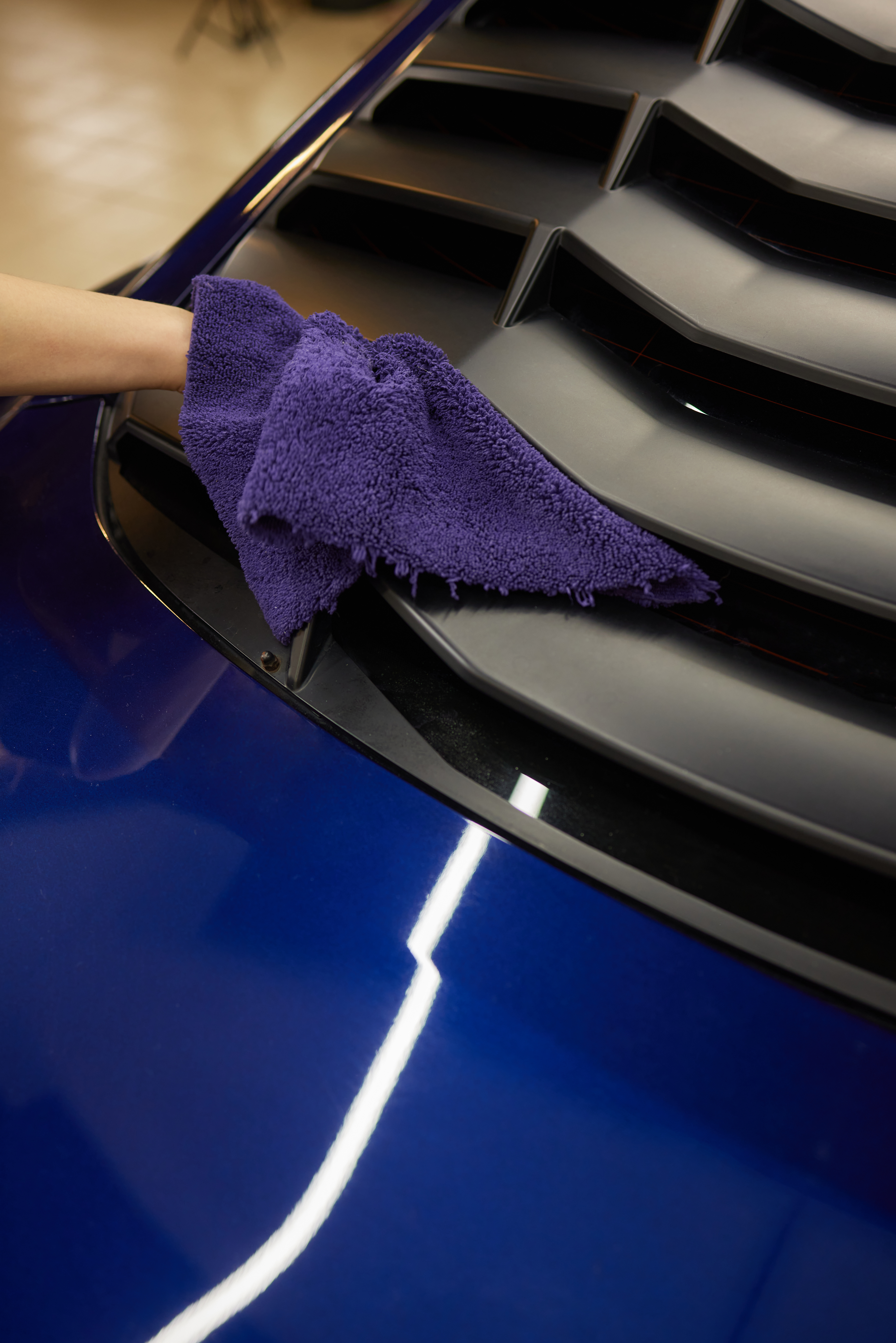 worker-car-detailing-cleaning-car-with-microfiber
